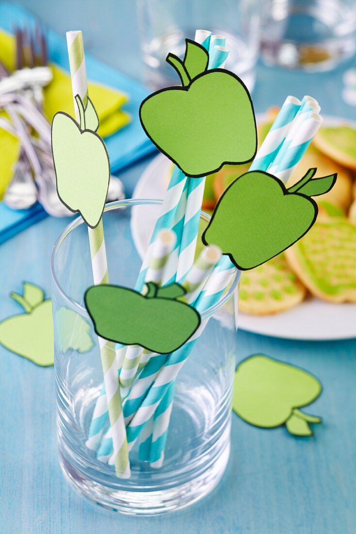 Drinking straws decorated with cut-out paper apples