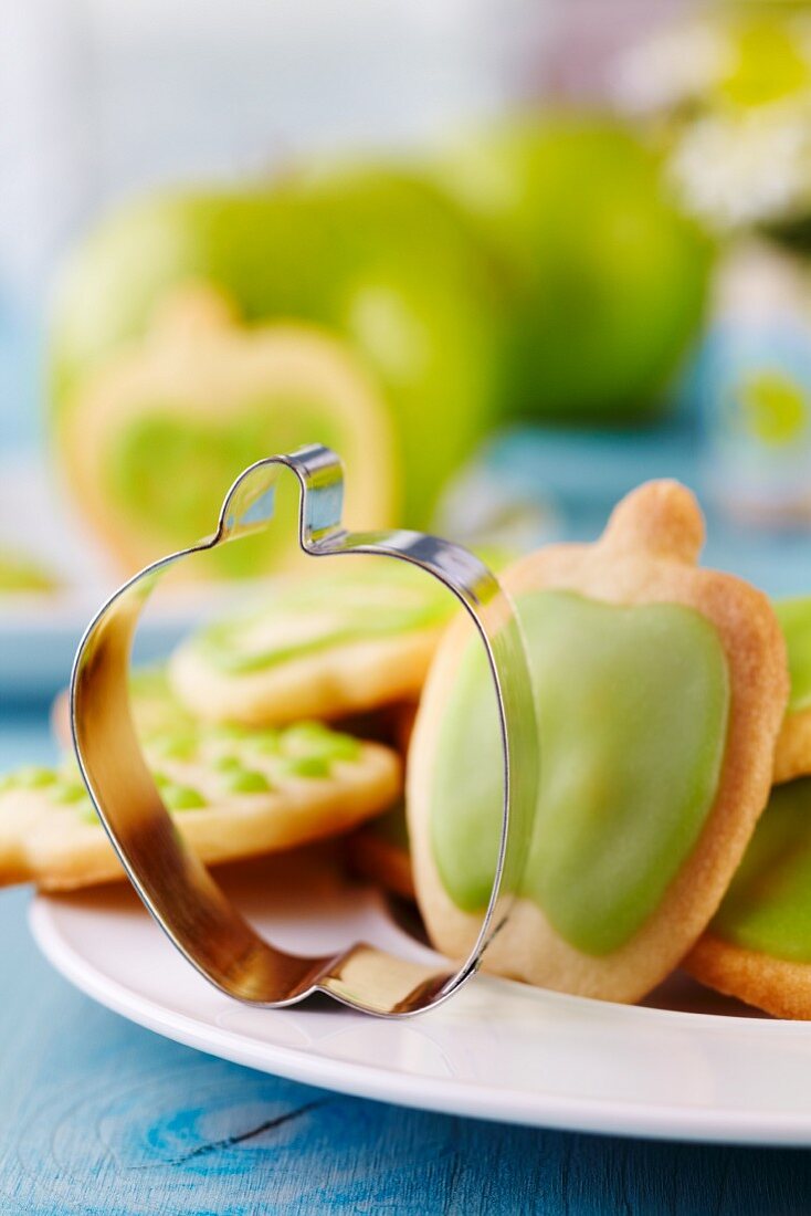 Keksausstecher in Apfelform auf Teller mit Keksen