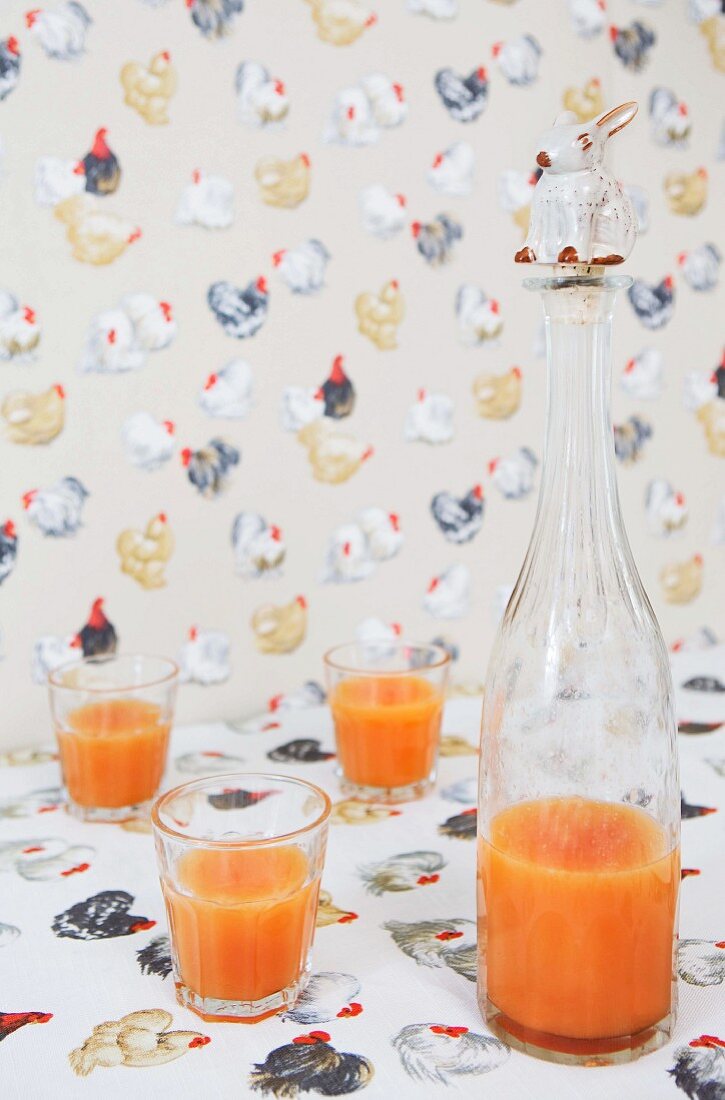Pattern of hens on tablecloth and wallpaper; stopper with rabbit figurine on bottle of breakfast drink