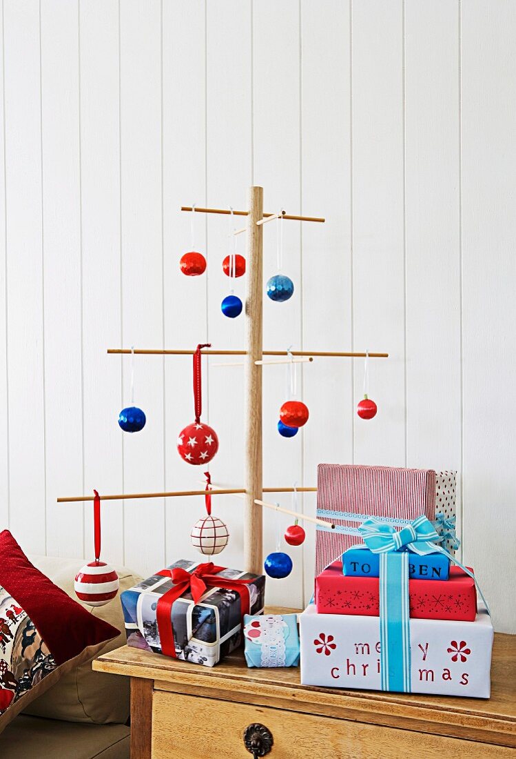 Weihnachtsbaum aus Holzstäben dekoriert mit Kugeln in blau, rot & weiss