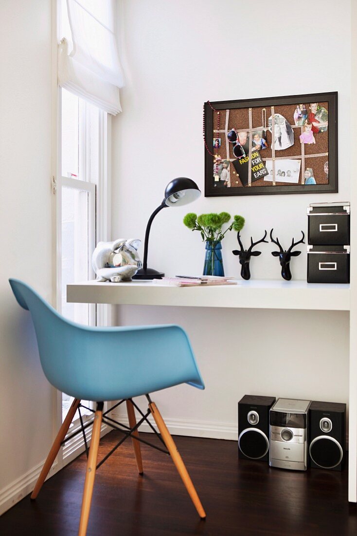 White desk, black accessories, floor-level window and sky blue, 50s retro shell chair