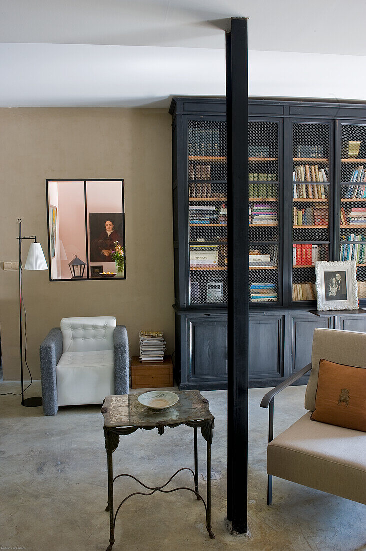 Leseecke mit Bücherregal, Sessel und Beistelltisch in Wohnzimmer
