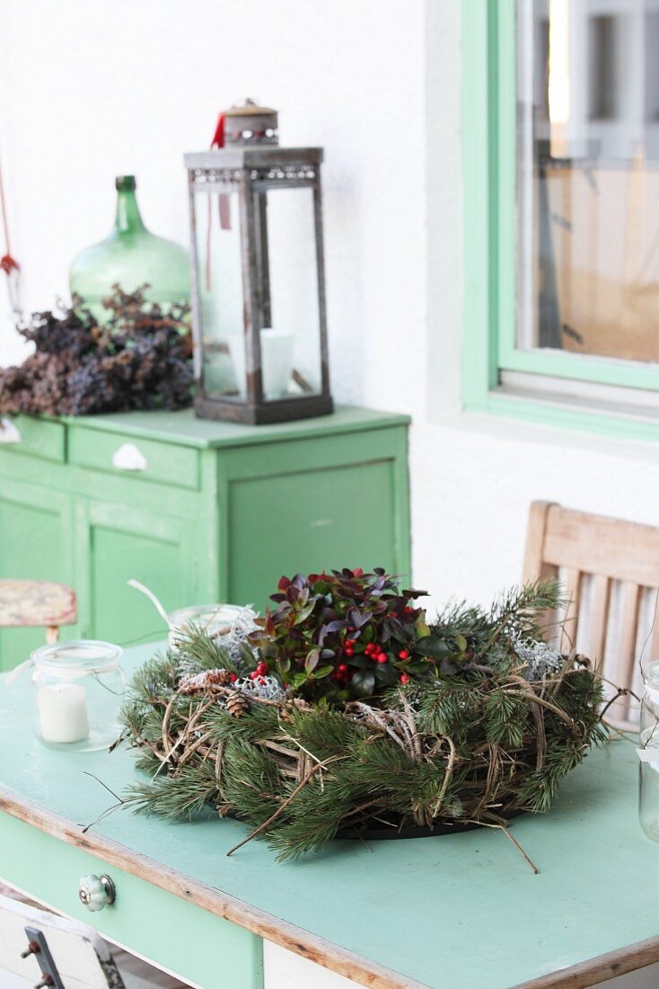 Rustic winter arrangement on old green furniture outside outside house