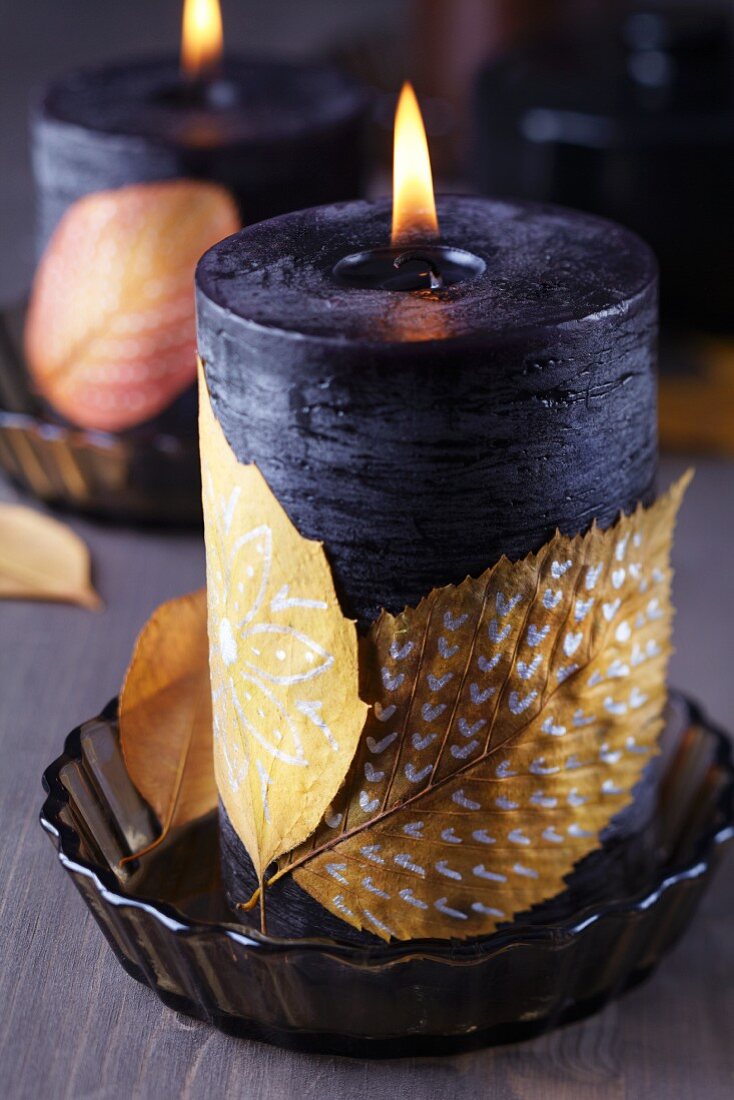 Kerze verziert mit bemalten Herbstblättern