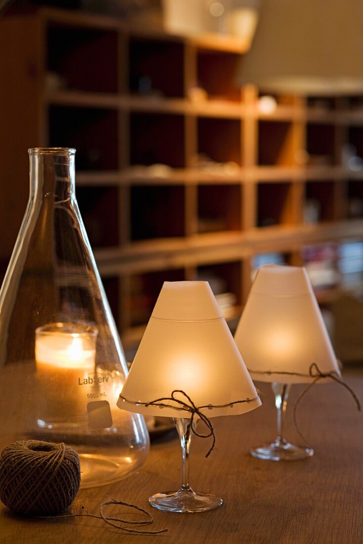 Selbstgemachte stimmungsvolle Kerzenleuchten aus Weingläsern mit Lampenschirm aus Wachspapiers