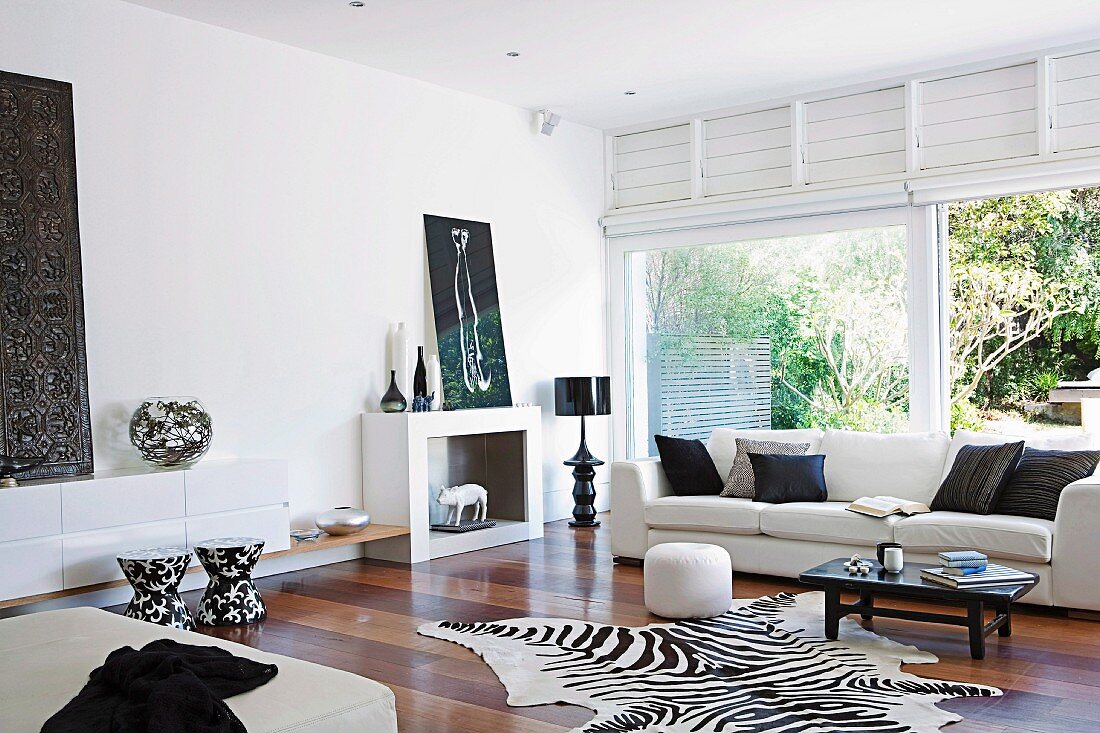 Elegantes Wohnzimmer mit hellem Sofa, Zebrafell und Terrassentür