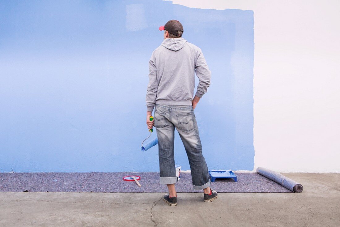Man admiring a freshly painted wall