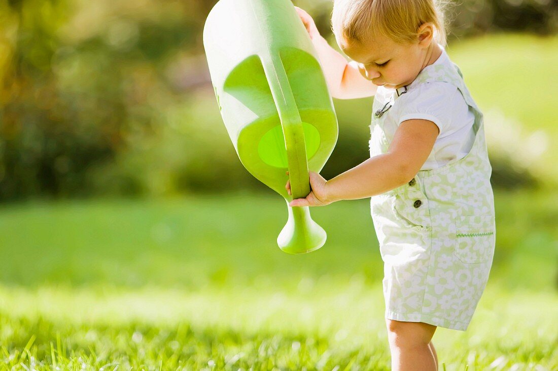 Kleinkind mit grüner Giesskanne