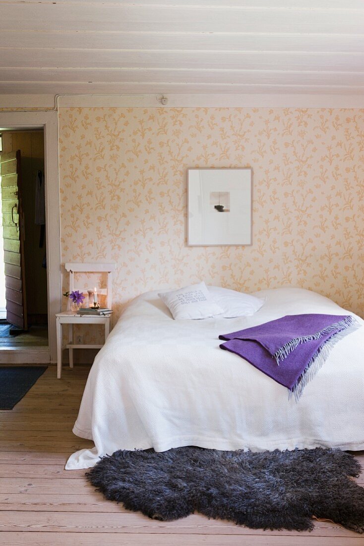 Schlafzimmer mit Holzboden, Holzdecke, Doppelbett & Fellvorleger
