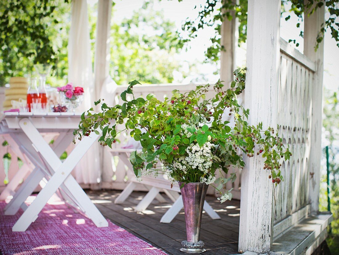 Gedeckter Tisch & Blumenarragenment in Gartenpavillon