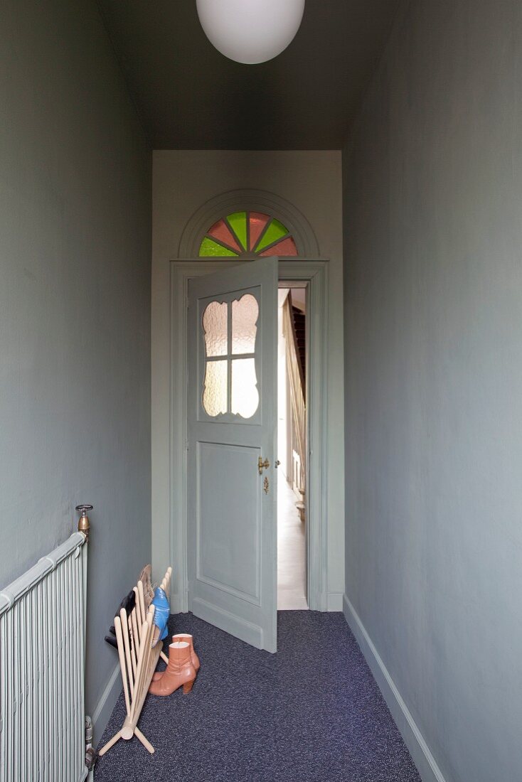 Nostalgische Zimmertür aus den 20er Jahren mit Türfenster und buntem Rundbogenfenster über dem Türrahmen