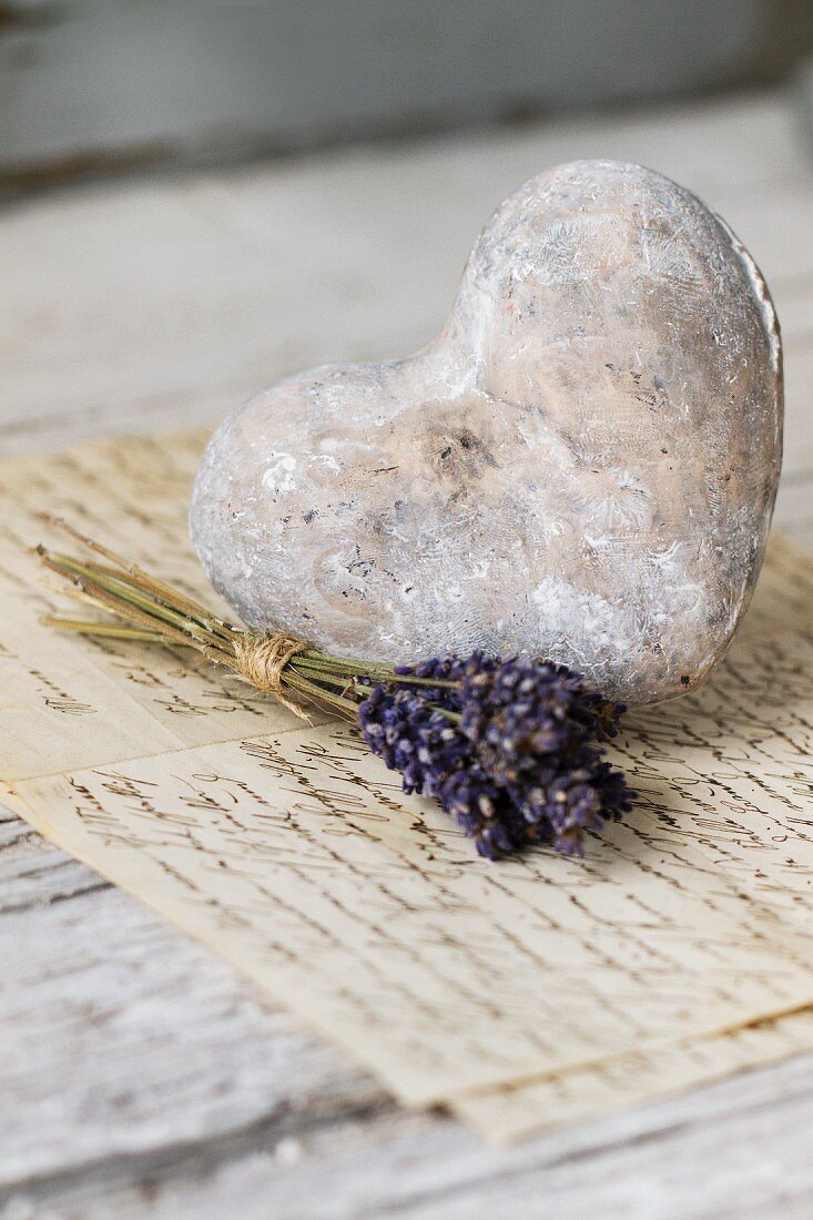 Dried lavender posy and vintage stone heart on handwritten letters