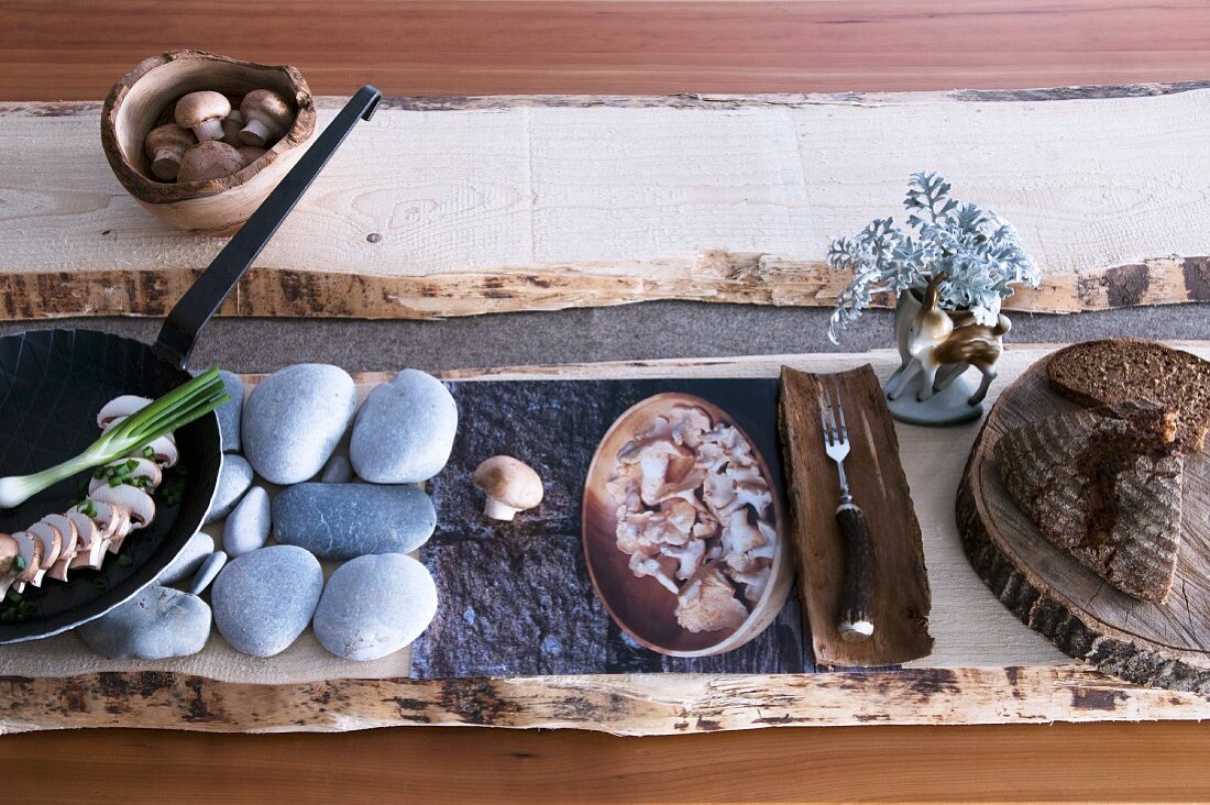 Stylised meal of mushrooms and bread with rustic ornaments of wood and stone