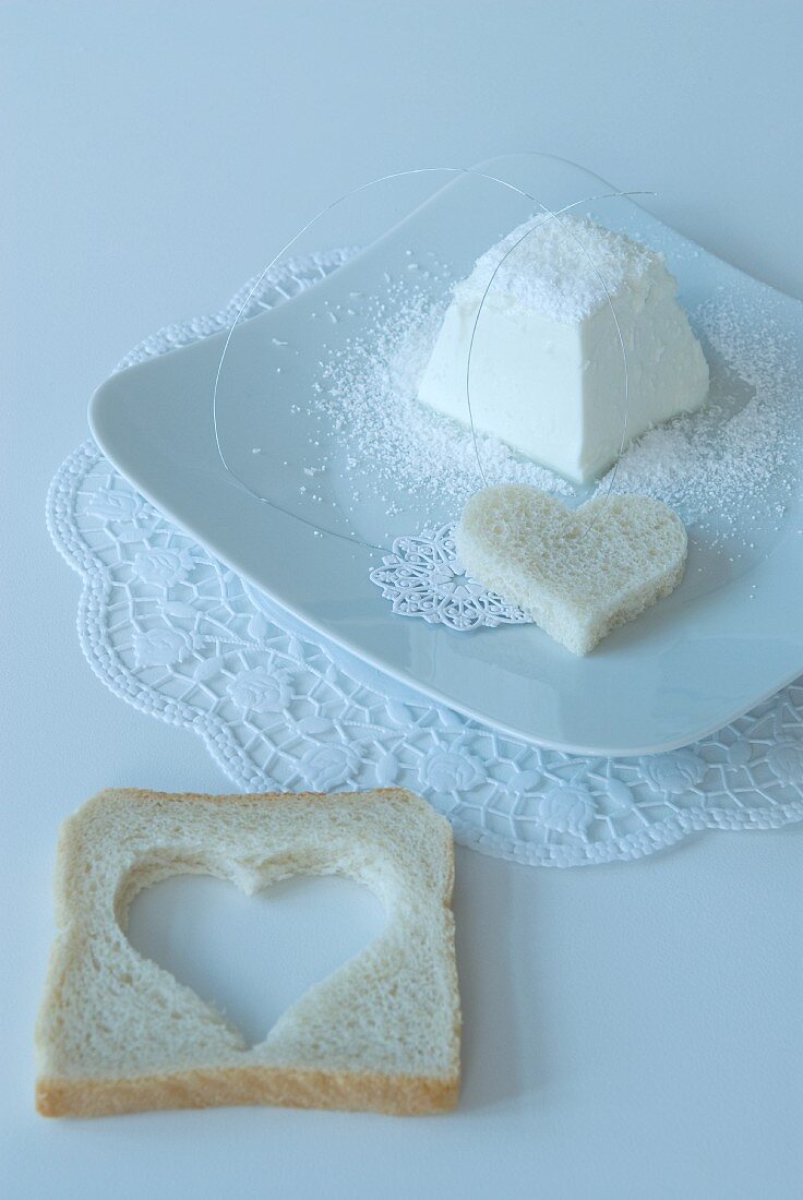 Weisses Gedeck mit herzförmigem Toast auf Spitzendeckchen