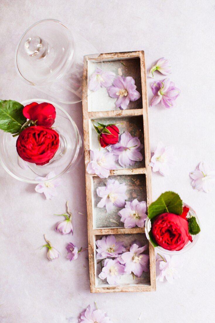 Lila Blüten und rote Rosen als Tischdeko