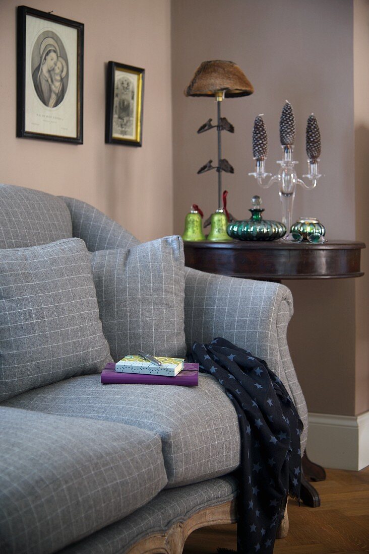 Sofa with grey upholstery and matching scatter cushions next to festively decorated console table