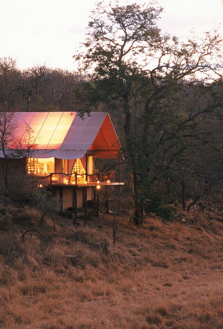 Twilight scene of illuminated holiday home in African landscape