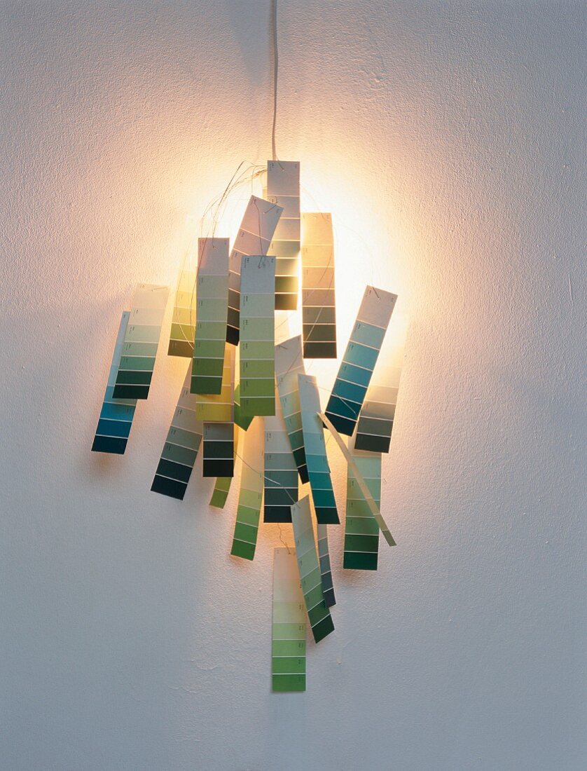 Hand-crafted sconce lamp made from paint colour charts threaded on wire