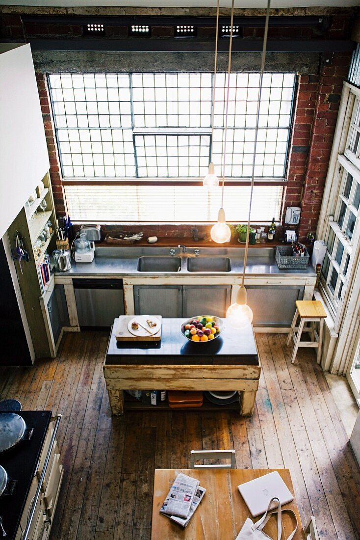 Spacious, vintage kitchen in loft apartment in old industrial building with wooden floor and brick walls