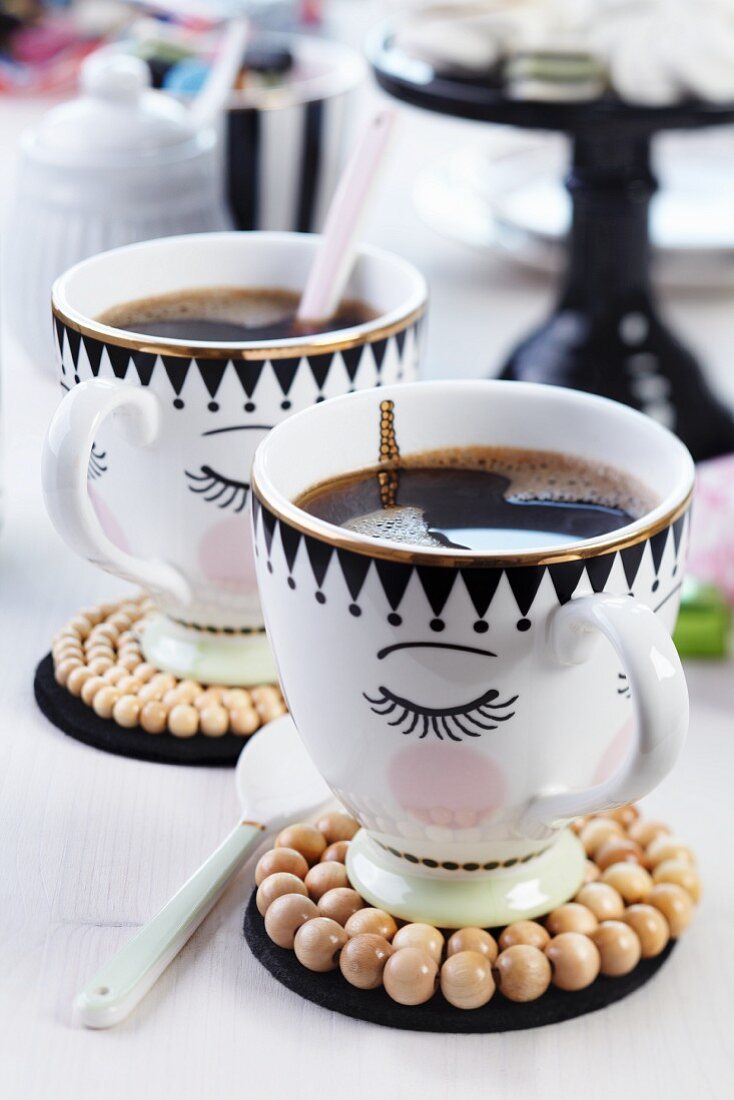 Painted coffee cups with coasters made from wooden beads