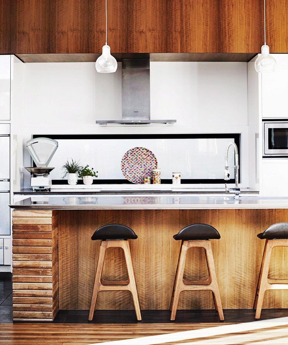 Retro Barhocker vor Theke mit rustikaler Holzfront in moderner Einbauküche