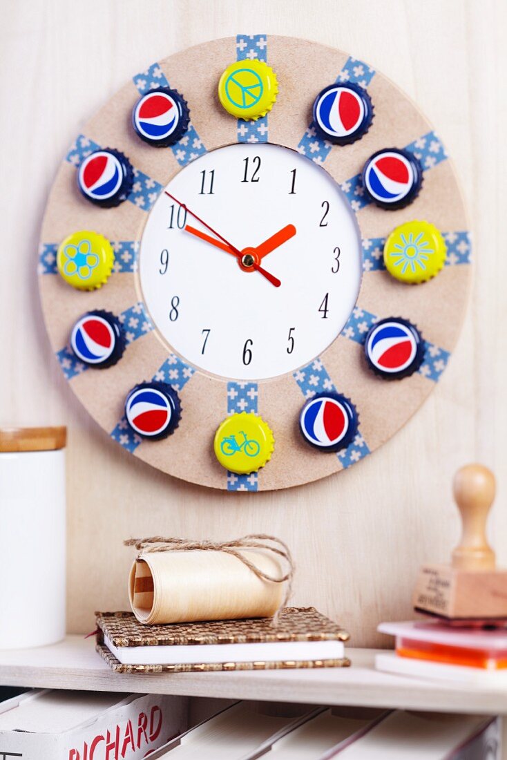 Round wall clock decorated with brightly painted bottle caps and washi tape