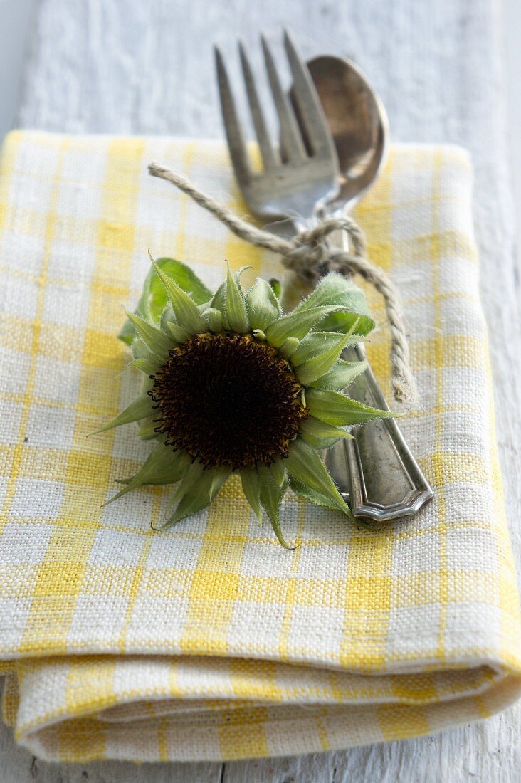 Sonnenblumenfruchtstand mit Besteck auf Serviette