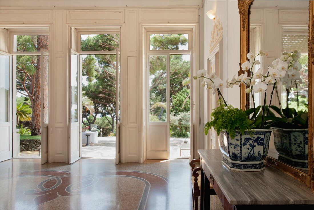 Eingangshalle einer ligurischen Villa aus den 20er Jahren mit Terrazzoboden und zum Piniengarten geöffneten Flügeltüren