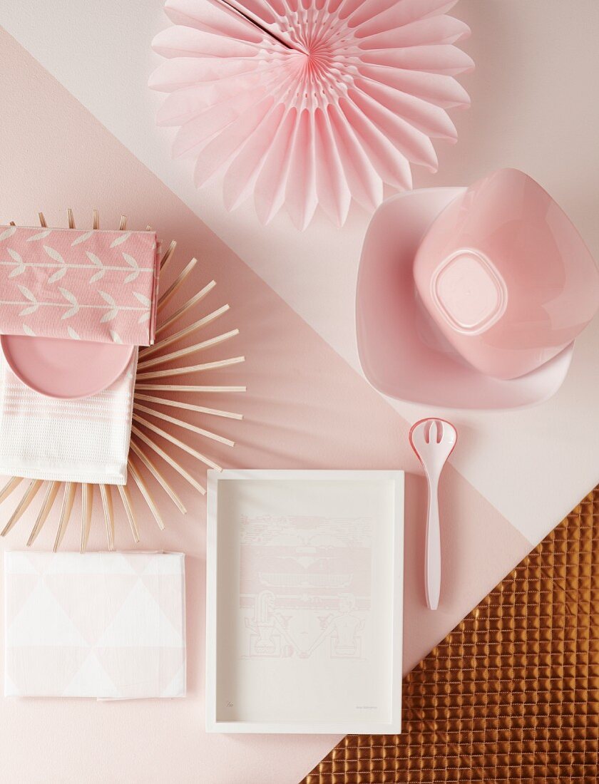 Kleine Tischdeko mit strahlenförmigem Set, Papierfaltblüte und Schalen in gehauchten Rosa- und Champagnertönen