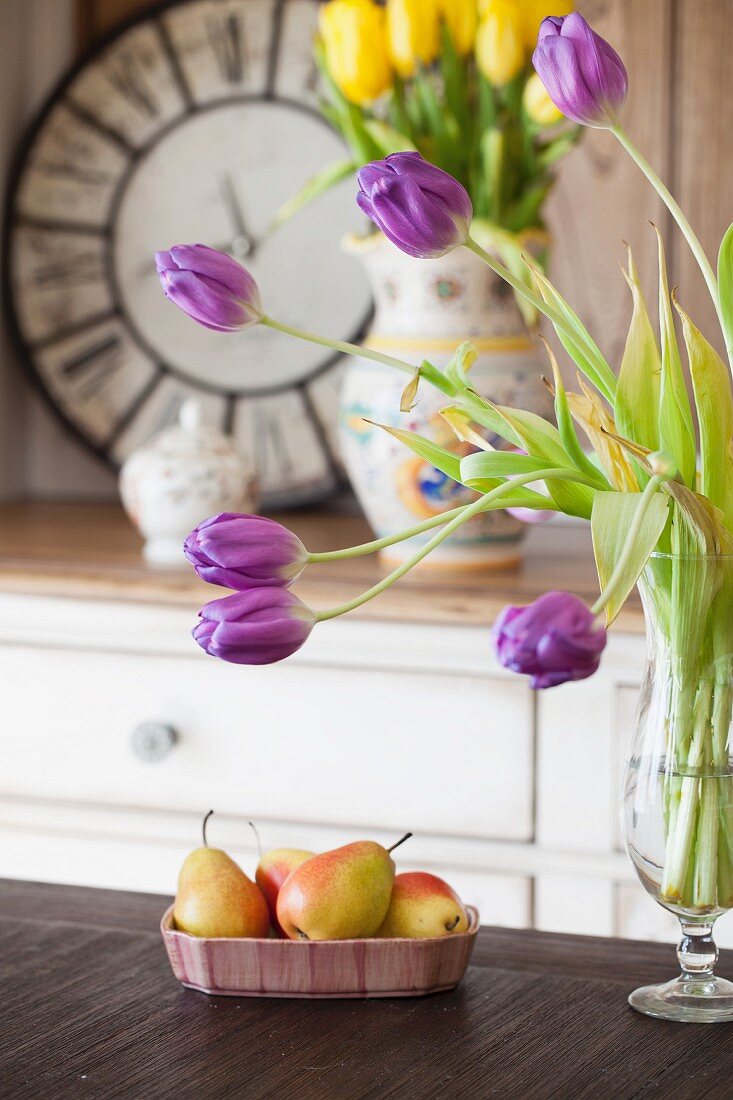 Purple and yellow tulips and bowl of pears in kitchen