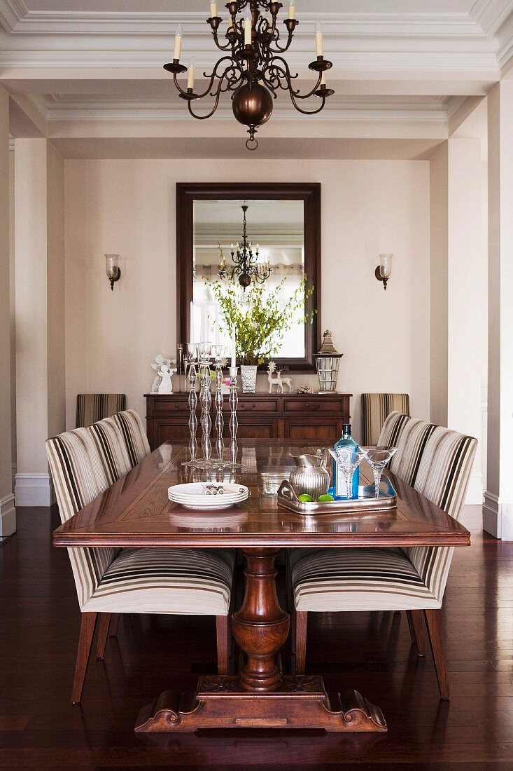 Antique table and striped upholstered chairs in elegant country-house dining area