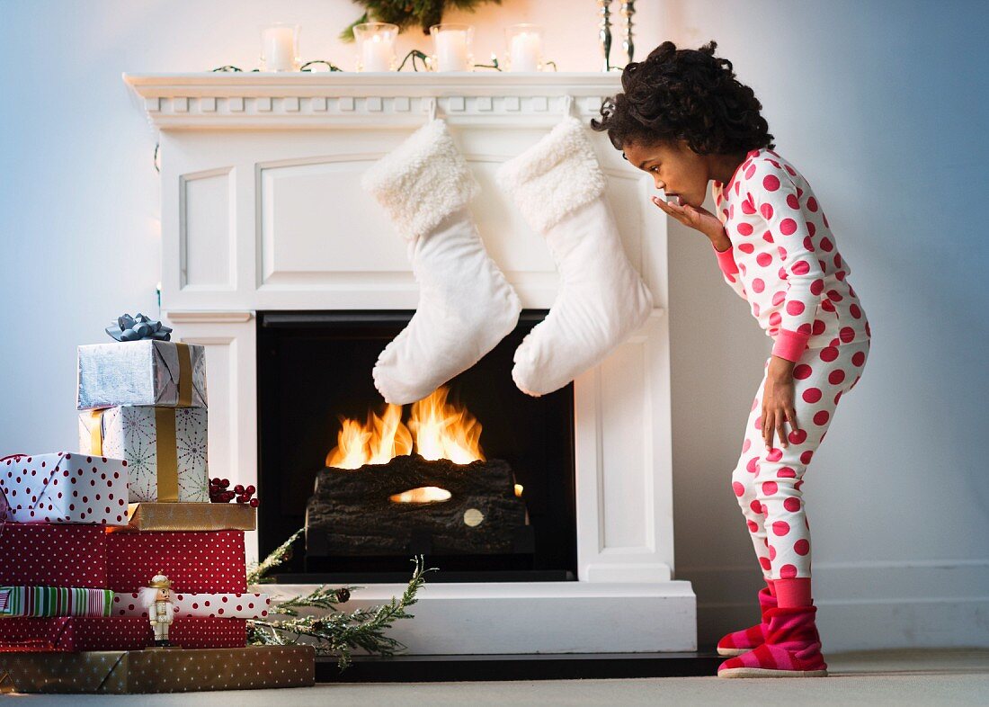 Little girl in front of festively decorated fireplace