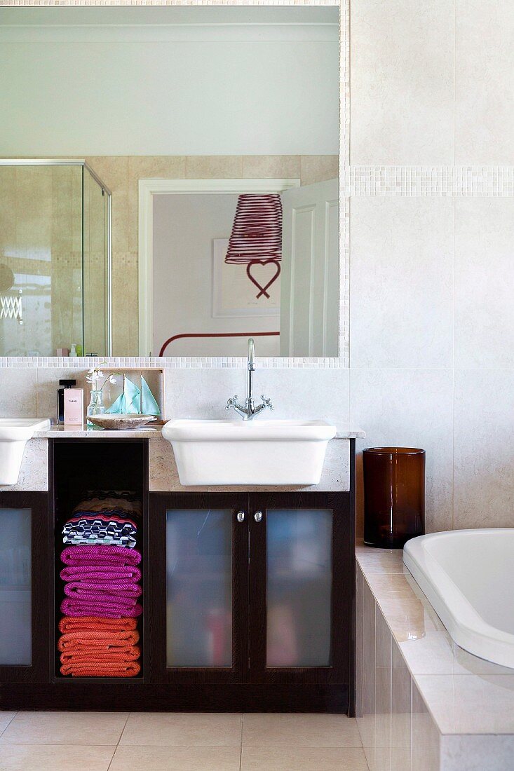 Badzimmer mit farbigen Handtüchern im Unterschrank des Waschtisches