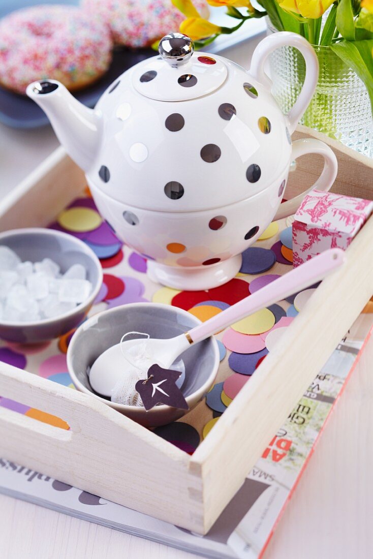 Polka-dot teapot and cup set on tray decorated with confetti