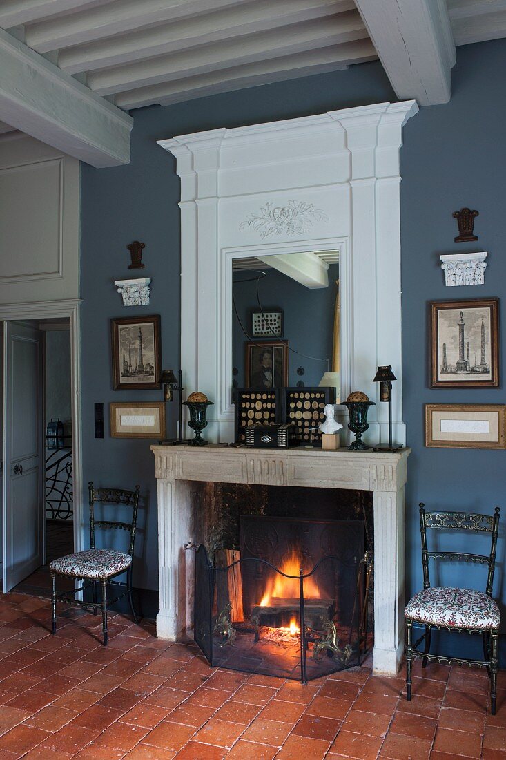 Traditional living room with open fire and mirror integrated into white-painted panel above mantelpiece