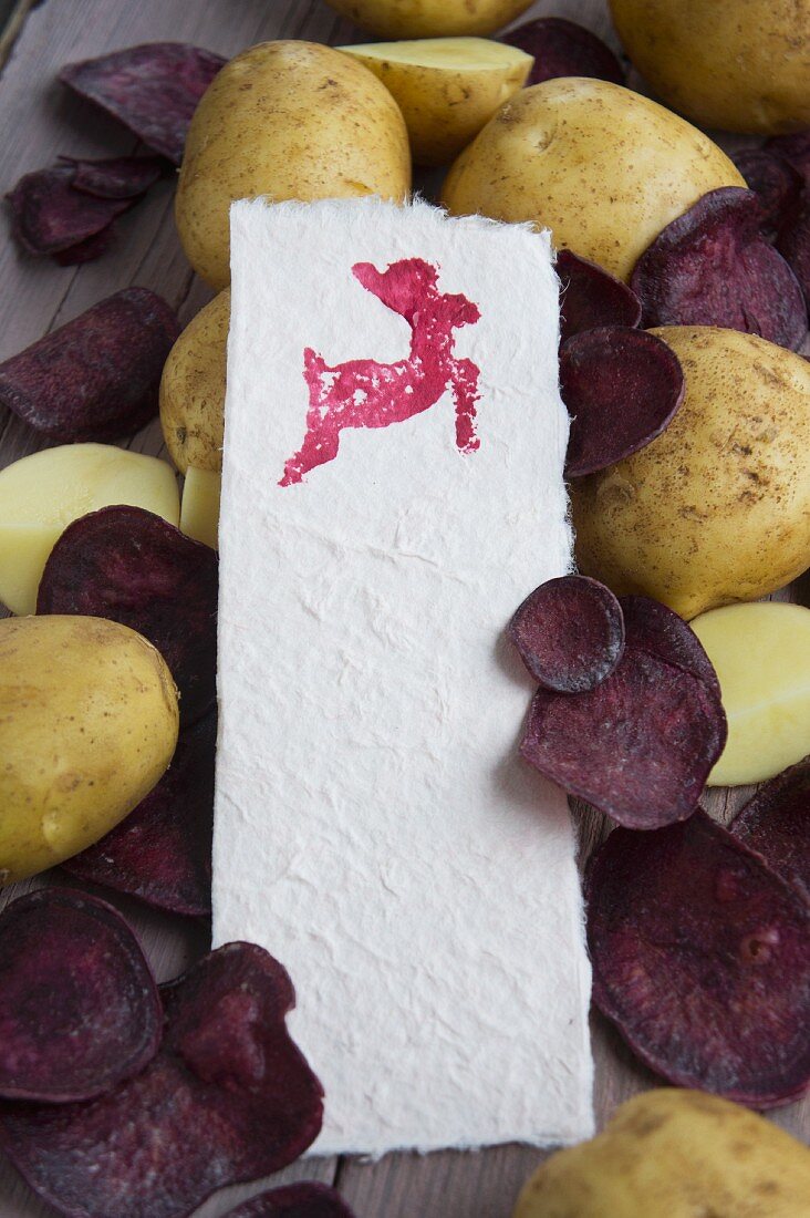 Potato print - paper stamped with animal print lying on potatoes and purple crisps