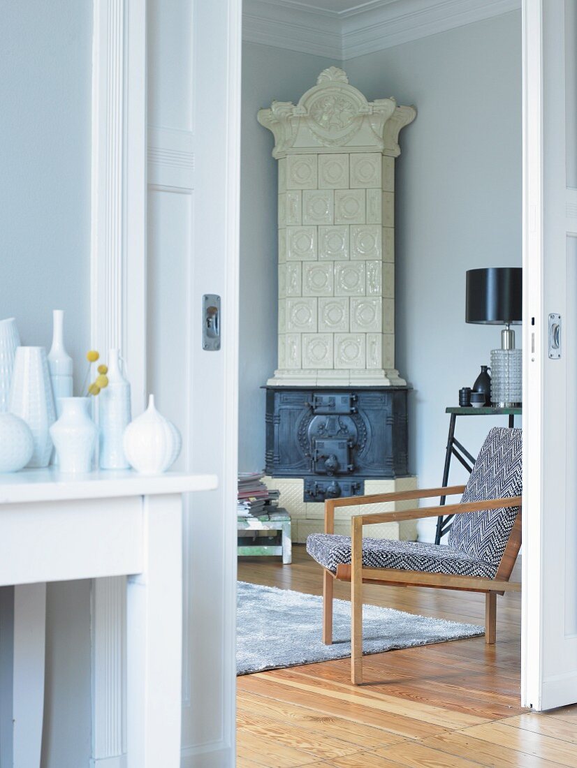 Wandtisch in Vorraum mit Vasensammlung neben offener Schiebetür und Blick auf Sessel, und Eckkamin in Zimmerecke