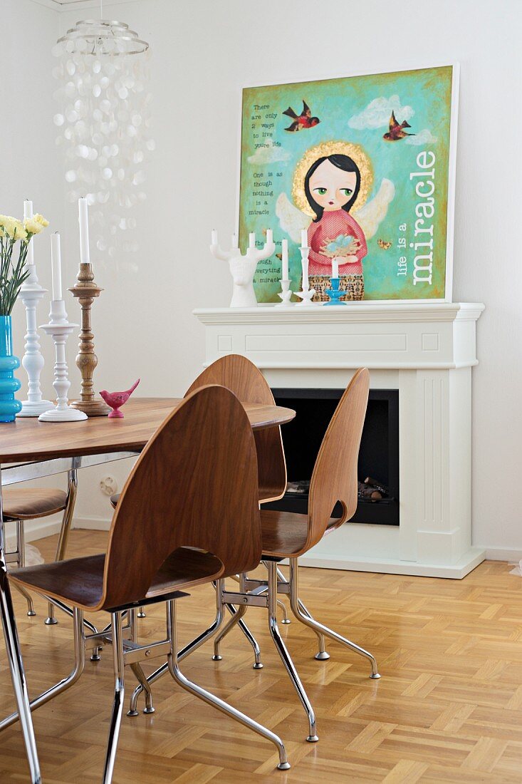 50s laminated wooden chair, round dining table and modern picture of angel on mantelpiece in background