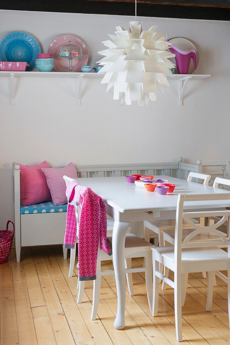50s artichoke designer lamp above dining set and bench in white, Scandinavian kitchen-dining room with pink accents