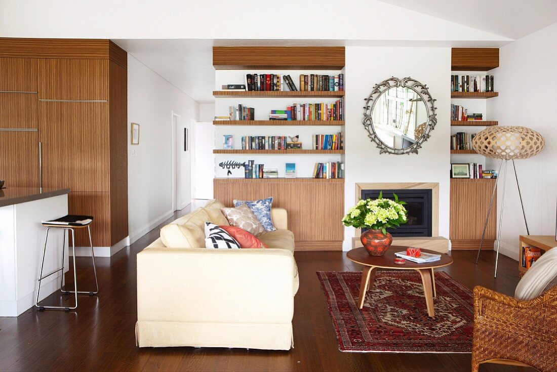 Helle Couch und Couchtisch im 50er Jahre Stil auf Teppich in modernem, offenem Ambiente
