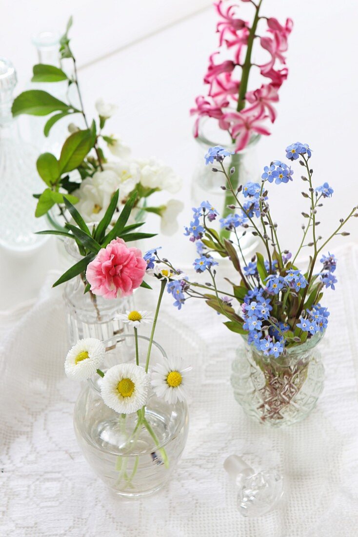 Vasen mit verschiedenen Blumen: Vergissmeinnicht, Nelke, Apfelblüte, Gänseblümchen, Hyazinthe