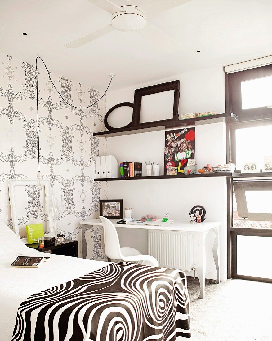 Schlafzimmer in Schwarz und Weiß mit Bett & Wandregalen über Schreibtisch