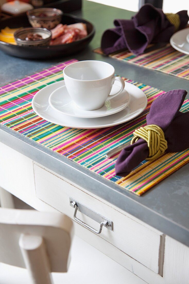 White breakfast place setting with linen napkin and striped place mat