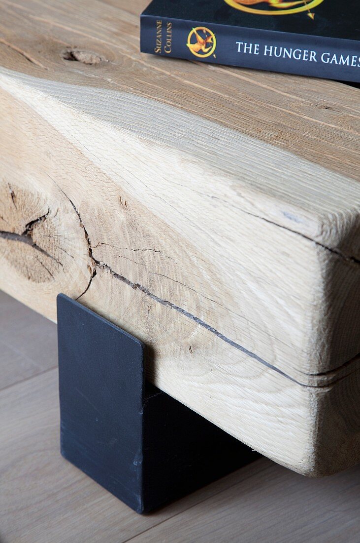 Detail of low wooden coffee table made of square timber on metal profile