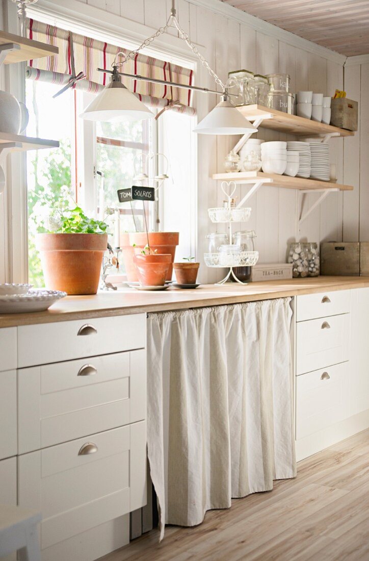 White country-house kitchen with worksurface below window
