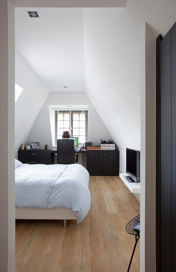 Bedroom in the attic with light-colored interior and office space