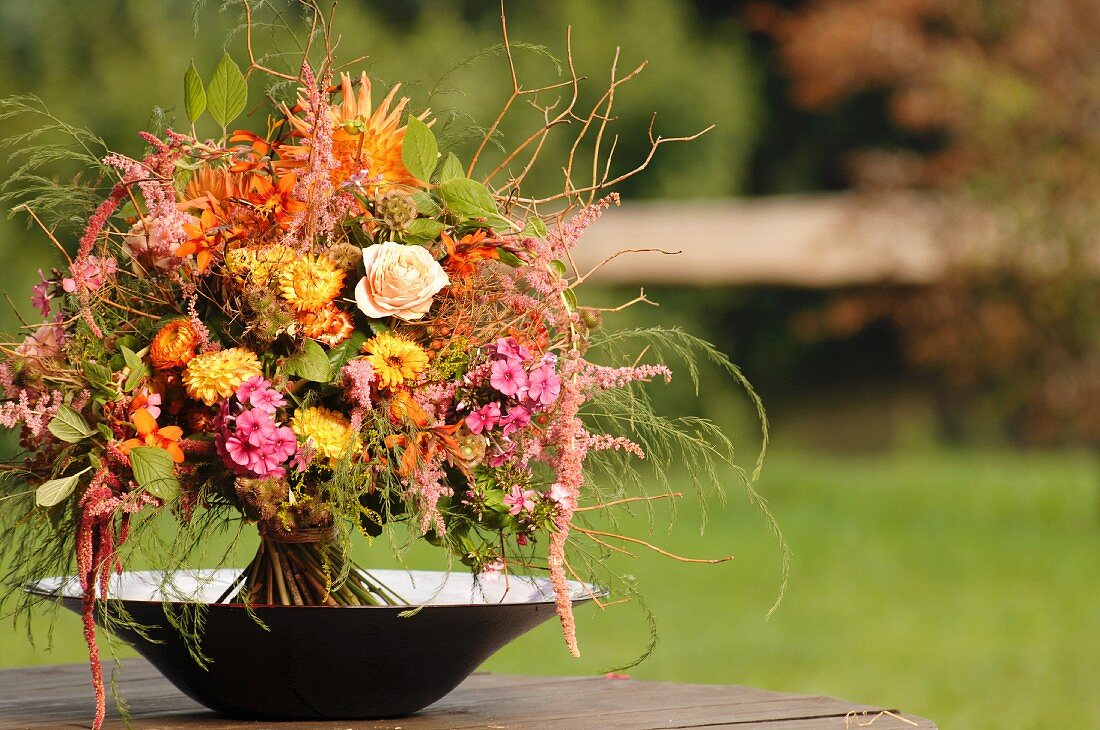 Autumnal, colourful bouquet of garden flowers in bowl