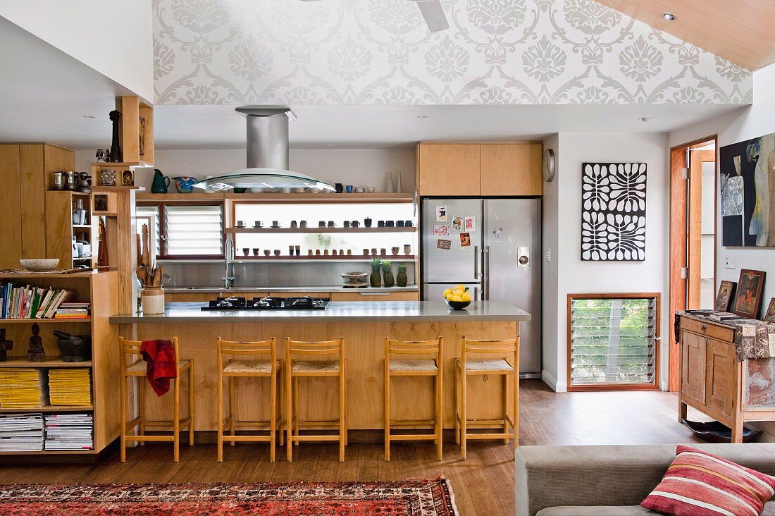 Offene Küche mit Holzfronten an Schränken und Theke, Barhocker, im Wohnraum mit traditionellem Flair