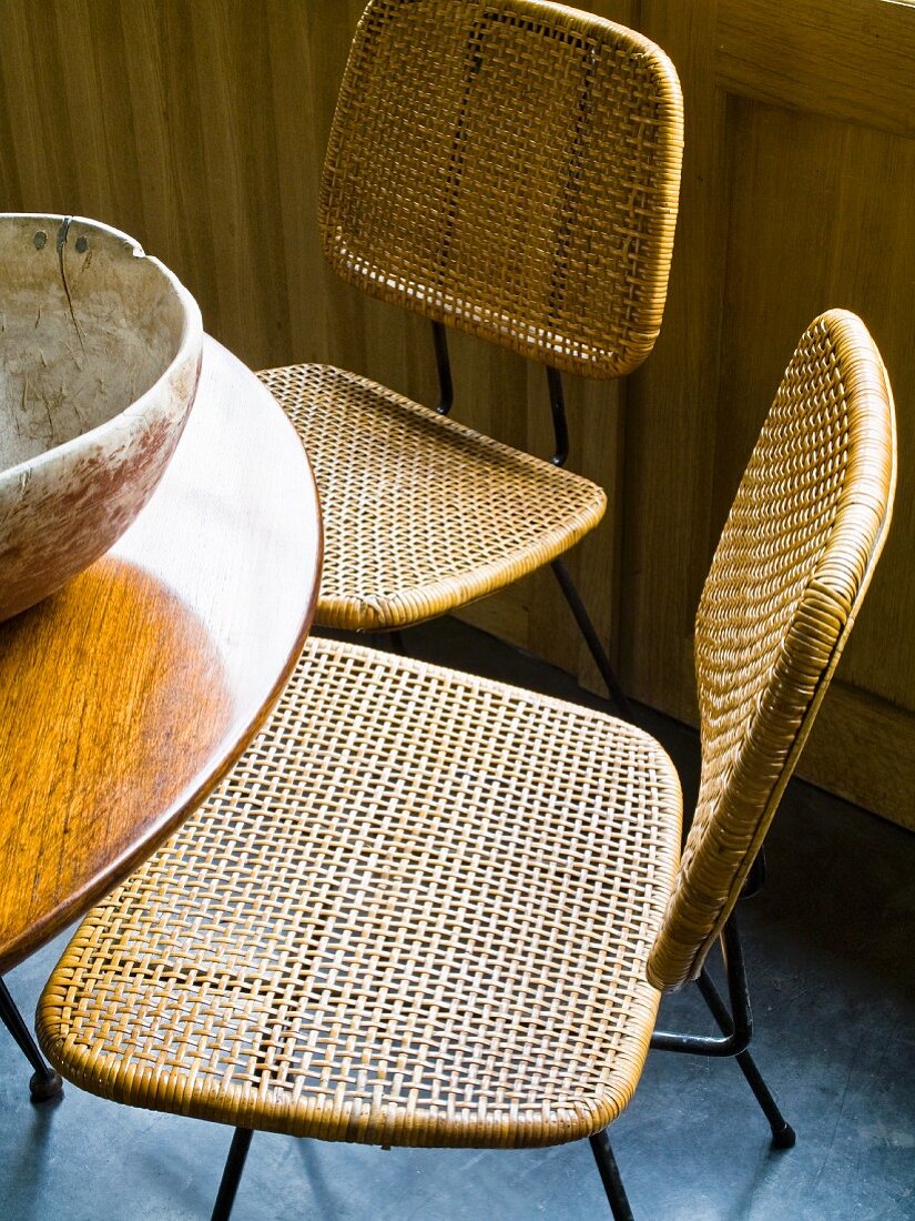 Fifties Stühle aus Metalldraht und Geflecht an rundem, poliertem Holztisch