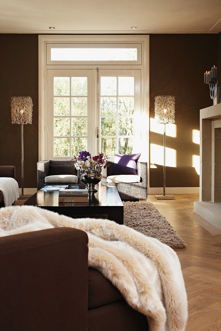 Elegante Sitzgruppe in Wohnzimmer mit Glasflügeltür, flankiert von Stehlampen